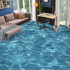 Op de afbeelding: Een woonkamer met een hoekbank, een bijzettafel en een bureau met een computermonitor. De vloer is bedekt met blauw water, waardoor de illusie van een zwembad ontstaat.