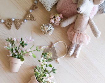 Dollhouse pink flower in a pot, miniature pink plant in a pot