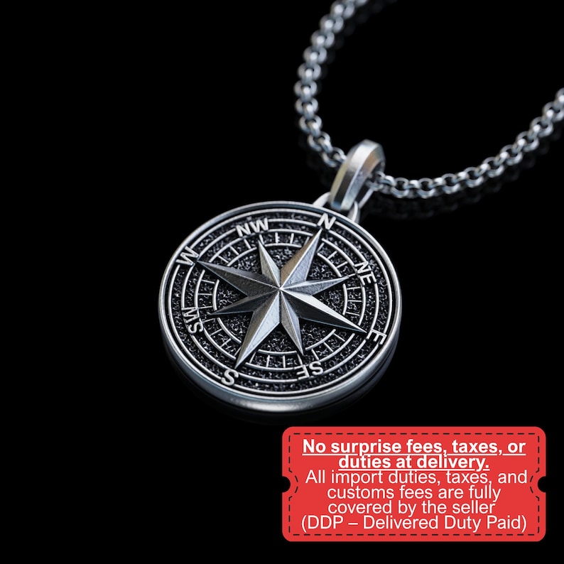 May include: Silver-toned compass pendant necklace. The pendant features a detailed compass rose design with directional markers and a central star. The necklace is on a silver chain, perfect for everyday wear.