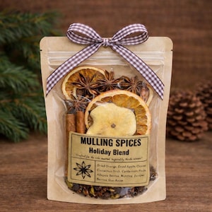 May include: A clear bag of mulling spices tied with a brown and white checkered ribbon. The bag contains dried orange slices, star anise, cinnamon sticks, and other spices. The label reads "Mulling Spices Holiday Blend".