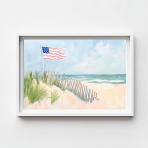 May include: A framed painting depicts a beach scene with an American flag waving in the wind. The artwork features a sandy dune, a wooden fence, and the ocean under a blue sky with clouds. The color palette includes shades of blue, pink, green, and beige.