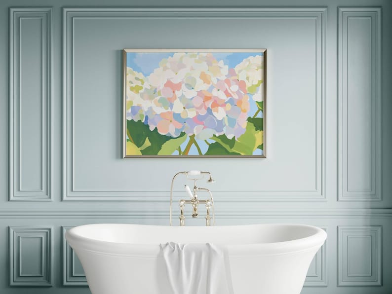 K&ouml;nnte beinhalten: Gerahmtes Blumenbild mit Hortensien in Wei&szlig;, Rosa und Blau vor hellblauem Himmel. Das Kunstwerk h&auml;ngt &uuml;ber einer wei&szlig;en Badewanne in einem Raum mit hellblauen W&auml;nden. Klassisches Design.