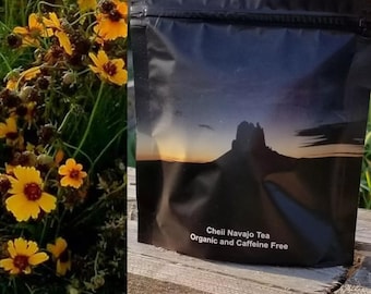 May include: A black resealable pouch with a mountain range silhouette and a sunset sky. The text "Cheii Navajo Tea Organic and Caffeine Free" is printed on the pouch.