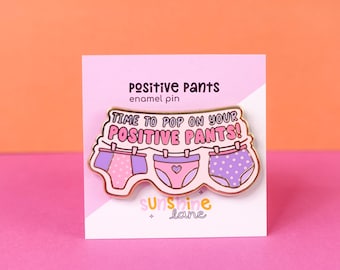 Spilla smaltata dorata Positive Pants: spilla con frase positiva e stendibiancheria. Indossa i tuoi pantaloni positivi!