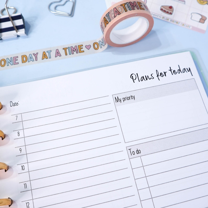 May include: A white planner with a blue cover and a section for "Plans for today". The planner has a section for "My priority" and a section for "To do".