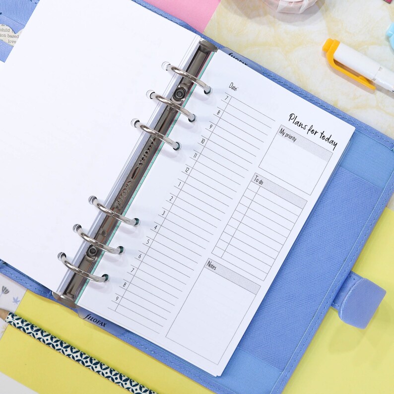May include: A blue planner with a white page open to a daily planner section. The page has a section for "Date", "My priority", "To do", and "Notes". The page is labeled "Plans for today".