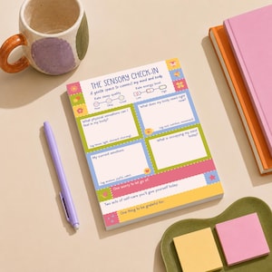 Può includere: Un blocco note rettangolare in carta intitolato The Sensory Check-In con sezioni per monitorare sonno, energia, sensazioni fisiche, bisogni corporei, emozioni e pensieri, caratterizzato da bordi colorati e piccole icone decorative.