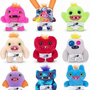 May include: Nine colorful plush monster toys with various colors and designs. Each monster has a unique face, two eyes, a mouth with teeth, and a tuft of orange or purple hair. They wear white diapers secured with a safety pin.