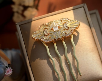 May include: Gold hair comb with a geometric design and clear rhinestones. The comb has five prongs.