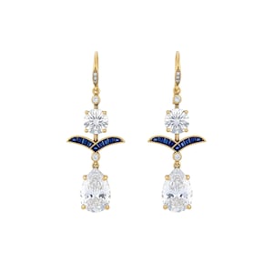 Peut inclure: Une paire de boucles d'oreilles pendantes dorées avec des pierres claires en forme de poire et rondes, et de petits accents bleus. Les boucles d'oreilles ont un design Art Déco.