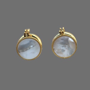 May include: A pair of gold-tone earrings with round white mother-of-pearl insets.