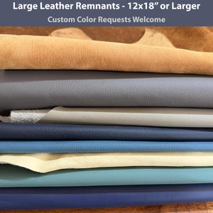 May include: A stack of large leather remnants measuring 12x18 inches or larger in various colors including tan, gray, beige, navy blue, light blue, cream, teal, and dark blue. The text Large Leather Remnants - 12x18" or Larger is visible at the top.