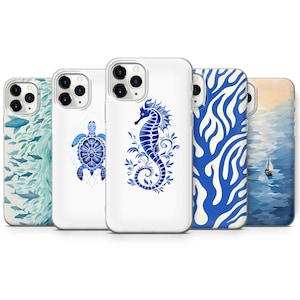 May include: A selection of white phone cases featuring blue marine designs. The designs include fish, a turtle, a seahorse, abstract wave patterns, and a sailboat on the ocean. The cases are displayed in a row.