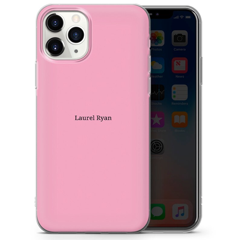 May include: A pink phone case with a clear back and a clear front. The case has a black inscription that reads "Laurel Ryan".