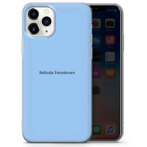 May include: A light blue phone case with a clear back. The case has a white inscription that reads "Belinda Fenniimore".