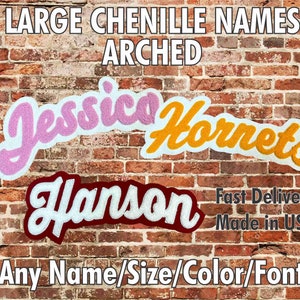 以下が含まれることがあります： レンガの壁に、アーチ状に「ジェシカ」、「ホーネッツ」、「ハンソン」の3つのシェニール製の名前が飾られています。名前はそれぞれピンク、イエロー、マロンです。画像の上部には「LARGE CHENILLE NAMES ARCHED」というテキストがあります。名前の下には「Fast Delivery Made in USA」というテキストがあります。画像の下部には「Any Name/Size/Color/Font」というテキストがあります。