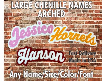 May include: Three chenille names, "Jessica", "Hornets", and "Hanson", are displayed in an arched style on a brick wall. The names are in pink, yellow, and maroon, respectively. The text "LARGE CHENILLE NAMES ARCHED" is at the top of the image. The text "Fast Delivery Made in USA" is below the names. The text "Any Name/Size/Color/Font" is at the bottom of the image.
