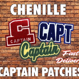 Könnte beinhalten: Chenille-Kapitänsaufnäher in Rot, Blau und Grün. Die Aufnäher zeigen das Wort "CAPTAIN" in verschiedenen Schriftarten und Designs. Der Hintergrund ist eine Backsteinmauer.