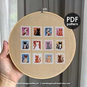 Puede incluir: Bordado de punto de cruz con ilustraciones de gatos en un diseño de sello. La obra de arte se muestra en un bastidor de bordado de madera. El texto "PDF pattern" es visible. El nombre y el sitio web del artista están en la parte inferior.