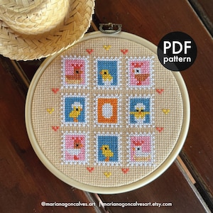May include: A cross-stitch pattern in a round frame featuring nine squares with bird designs in pink, blue, and orange. The text "PDF pattern" is in a black circle. The Etsy shop name and URL are at the bottom.