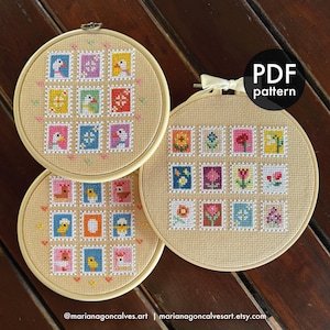 May include: Three cross-stitch embroidery hoops with colourful postage stamp designs. Each stamp features a different bird or flower. The hoops are set against a neutral fabric background. The text "PDF pattern" is visible on one hoop.