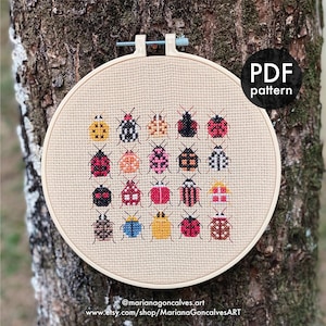 Peut inclure: Un motif de point de croix repr&eacute;sentant divers col&eacute;opt&egrave;res color&eacute;s, pr&eacute;sent&eacute; dans un cercle &agrave; broder en bois. Les insectes sont dispos&eacute;s en grille, avec une vari&eacute;t&eacute; de couleurs et de motifs. Le texte "PDF pattern" est dans un cercle noir. Le nom de l'artiste et l'URL de la boutique sont en bas.