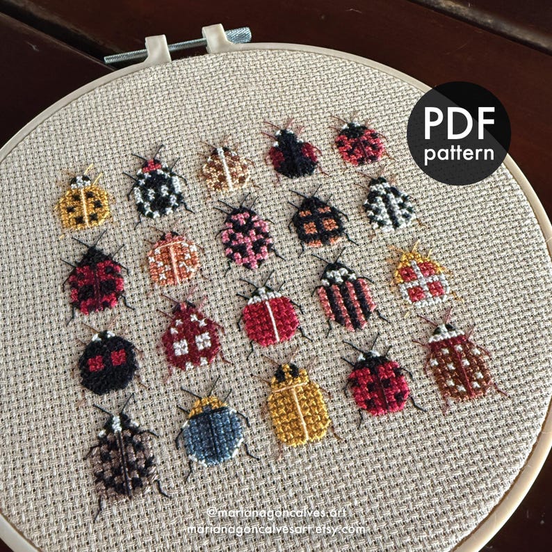 Peut inclure: Un tambour de broderie au point de croix avec divers motifs d'insectes color&eacute;s. Les insectes sont brod&eacute;s dans diff&eacute;rentes couleurs et motifs, dont le rouge, le noir, le jaune et le blanc. Le texte "PDF pattern" est visible.