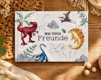 Puede incluir: Un libro infantil titulado "Meine Starken Freunde" con ilustraciones de dinosaurios. La portada muestra un T-Rex rojo, un estegosaurio amarillo y otros dinosaurios, sobre un fondo claro con follaje verde.