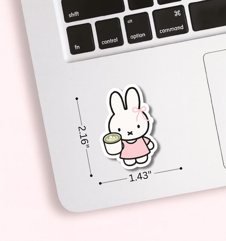 May include: A sticker featuring a cartoon bunny holding a cup of coffee. The bunny is white with a pink bow and dress. The sticker measures 2.16 inches by 1.43 inches.