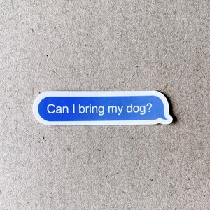 Close-up of “Can I bring my dog?” sticker on textured cardboard background.