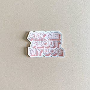 waterproof light pink sticker that reads ask me about my dog against cream background