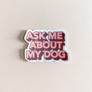 pink and dark red sticker that reads ask me about my dog against pink background