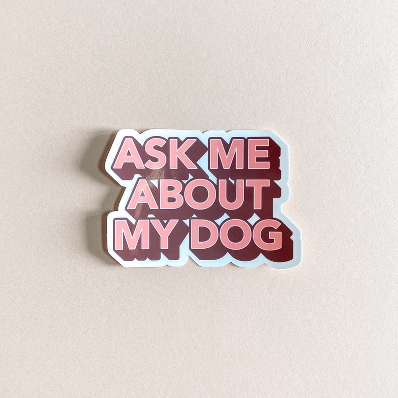 pink and dark red sticker that reads ask me about my dog against pink background