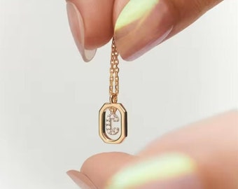 May include: A gold chain necklace with a pendant featuring the letter "C" set with small diamonds in a geometric frame.