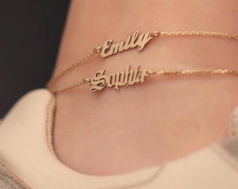 May include: Two gold anklets with the names "Emily" and "Sophia" written in cursive.
