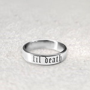 May include: A silver band ring with the words "til death" engraved in a gothic font.