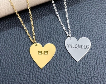 May include: Two gold and silver heart-shaped necklaces with personalized engravings. The gold necklace has the initials "BB" engraved on the heart pendant. The silver necklace has the text "YHLQMDLG" engraved on the heart pendant.