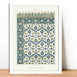 May include: Framed print featuring a detailed, vintage arabesque design. The artwork showcases a repeating floral pattern in shades of blue, green, and cream, with intricate border details. The print is set in a white frame, adding a classic touch.