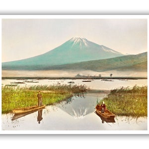 May include: A vintage postcard depicting Mount Fuji reflected in a lake with two people in small boats. The mountain is green and snow-capped, with a misty background.