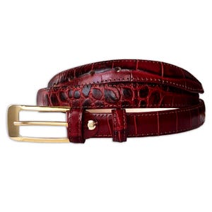 May include: A deep burgundy belt featuring a textured crocodile-embossed pattern throughout the strap. The belt is equipped with a polished gold-tone rectangular buckle and a matching gold-tone metal stud on the belt loop for secure fastening.