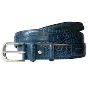 May include: A dark blue belt featuring a textured crocodile skin pattern. The belt includes a polished silver-tone metal buckle and a matching silver-tone metal stud detail on the belt loop, showcasing a refined and structured design.