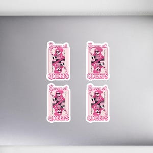 May include: Four stickers with a pink and white design featuring a cartoon queen holding a skull and the text "Queen of Queefs". The stickers are rectangular with rounded corners and are placed on a gray laptop.