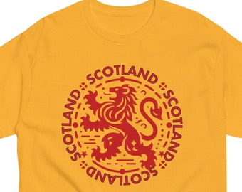 May include: A yellow t-shirt with a red graphic of a lion and the word "Scotland" repeated around the lion.