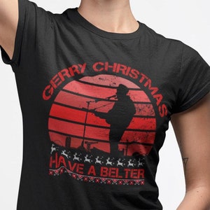 May include: Black t-shirt with a red graphic of a person singing into a microphone with the text "Gerry Christmas Have a Belter" underneath. The person is silhouetted against a red and white sunset.
