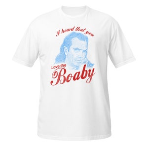 Puede incluir: Camiseta blanca con un estampado gráfico azul y rojo de la cara de un hombre con el texto "I heard that you Love the Boaby"