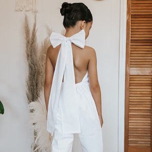 Handgemachter Blumenmädchen Jumpsuit: Weißer Baumwoll-Strampler mit Schleife