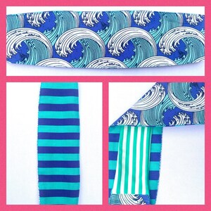 Pode incluir: Uma faixa de cabeça de tecido azul e branco com um padrão de ondas e o texto "a smooth sea never made a skilled sailor". A faixa de cabeça é reversível e tem um padrão de listras azuis e verdes do outro lado.