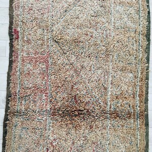 May include: A vintage rug with a faded, intricate pattern in shades of beige, brown, and red. The rug has a worn, distressed look, adding to its character.