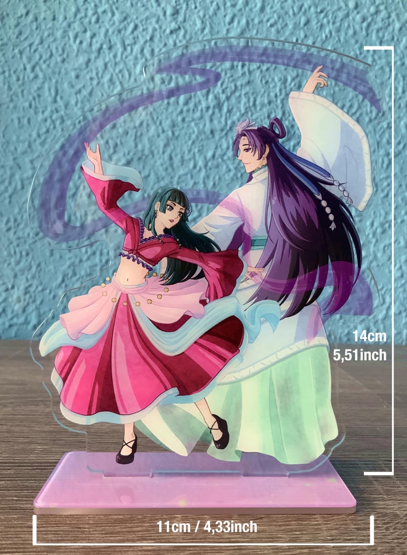 May include: A clear acrylic stand with two anime characters. The female character is wearing a pink and red dress with a blue sash. The male character is wearing a white and green robe with long purple hair. The stand is 5.51 inches tall and 4.33 inches wide.