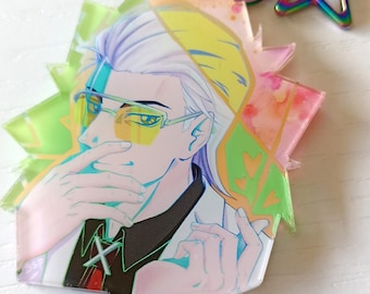 Peut inclure: Un porte-clés en acrylique représentant un personnage de style anime aux cheveux clairs et aux lunettes teintées de jaune, portant une blouse blanche sur une chemise sombre. Il possède un fermoir en métal irisé en forme d'étoile.